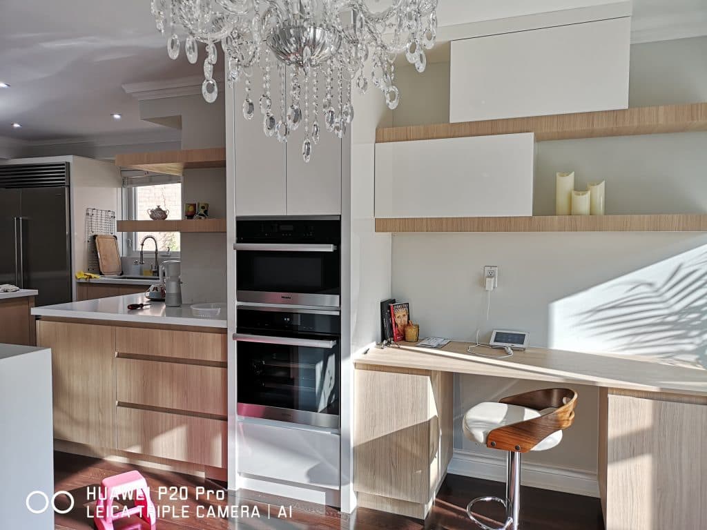 Contemporary Kitchen Featuring Wood Grain Finishes, Handle-Less Design, and Corner Floating Shelf